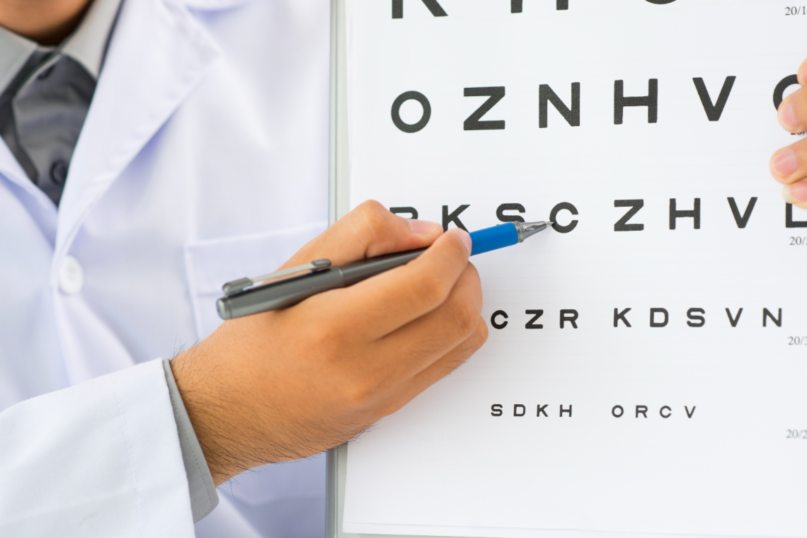 Eye doctor at Durham Vision Care in Oshawa Ontario pointing to eye chart in Whitby